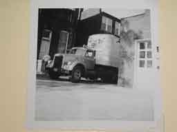 <p>Obviously a truck used to haul all of the television production equipment.  This photo shows the truck parked in an alley behind the town square.  I cannot make out all of the wording on the truck's sign, posted just above the cab, but it appears to say "Watch it on TV, Route 66" followed at the bottom by "Starring Martin Milner and George Maharis."</p>